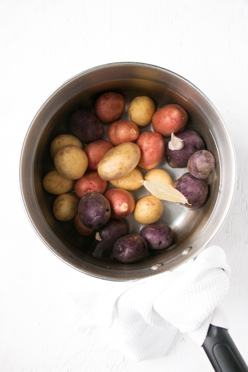 Little potatoes in a sauce pan with flavour boosters, covered in water. 