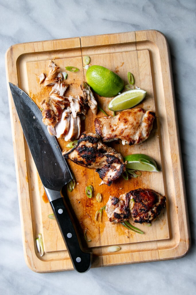 Lemongrass Chicken being cut up on a meat cutting board