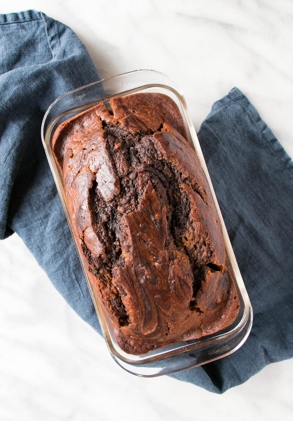 Glossy topped chocolate pumpkin loaf in a clear baking pan.