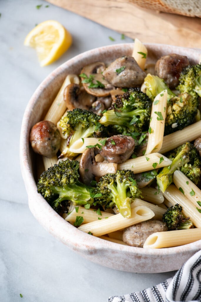 Roasted Sausage and Broccoli Pasta up close with a scattering of chopped bright green parsley on top.