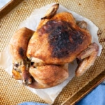 Slow Cooker Roast Chicken with crispy dark golden brown skin on a baking sheet.