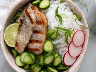 Vietnamese Noodle Bowls with grilled thin pork chops, sliced mini cucumbers, bright pink radishes, rice noodles and thinly sliced basil.